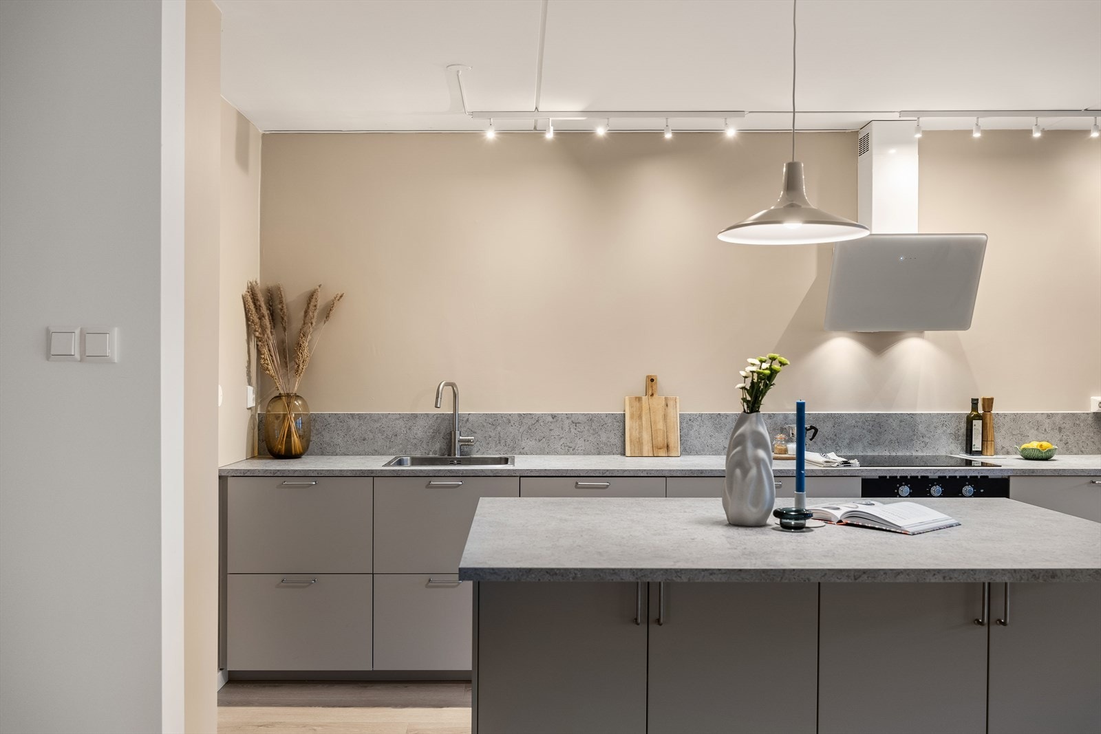 Benkeplaten strekker seg opp mot veggen og fungerer som en type beskyttelse for vannsøl ved matlaging. Stikkontakter er plassert like over kjøkkenbenken. Galleribilde