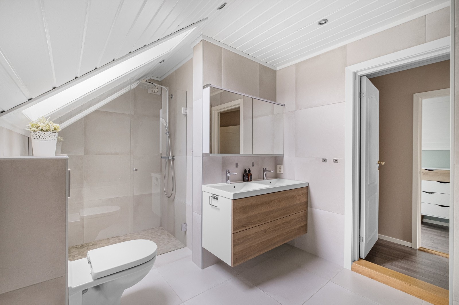 Badet i loftsetasjen er et moderne badet fra 2019. Her finner du et flislagt gulv med behagelig gulvvarme og flislagte vegger som skaper en elegant atmosfære. Galleribilde