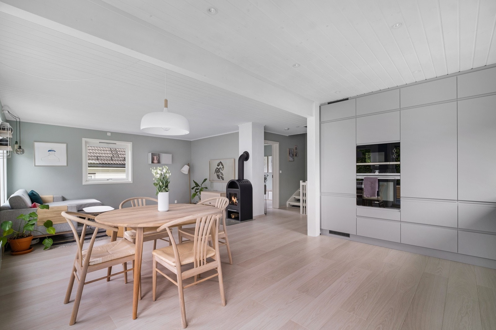 Moderne kjøkken med en åpen planløsning som harmonisk integrerer seg med stuen. Galleribilde