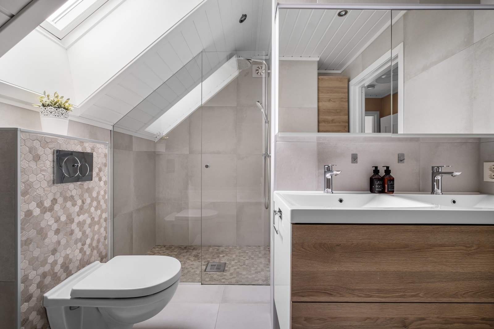 Et speilskap med lys og stikkontakt over servanten gir ekstra funksjonalitet. Galleribilde