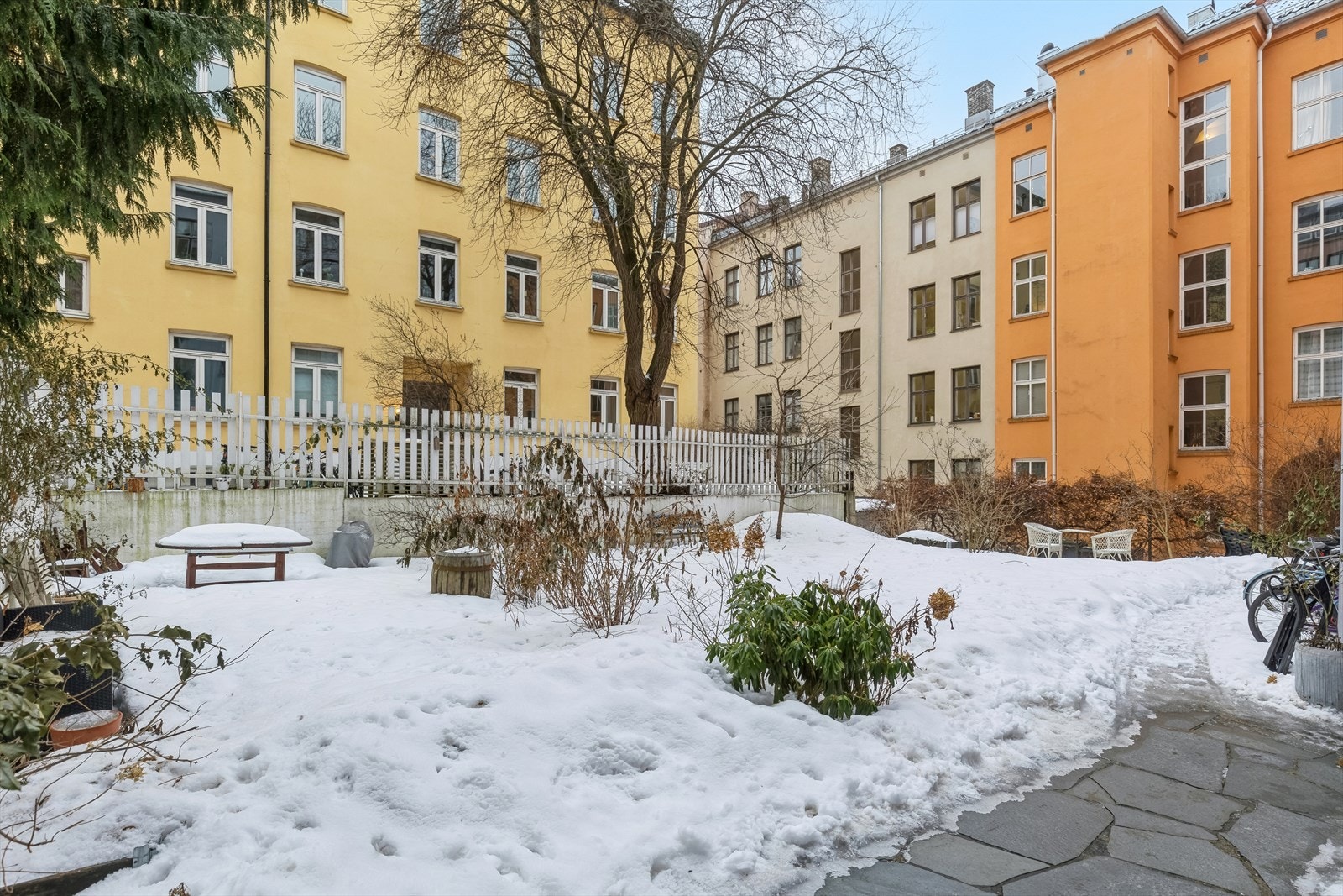 Bakgården er pent opparbeidet med gressplen, beplantning, steinbelagte arealer og sittegrupper. Galleribilde