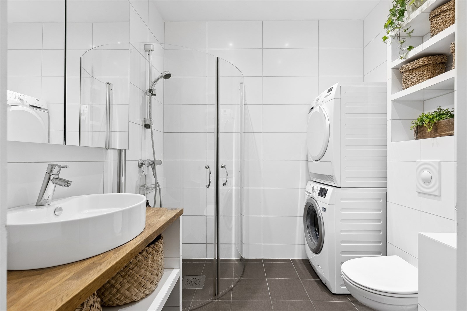 Badet er utstyrt med bl.a. romslig dusjhjørne, vegghengt klosett, speilskap og vaskesøyle. Galleribilde