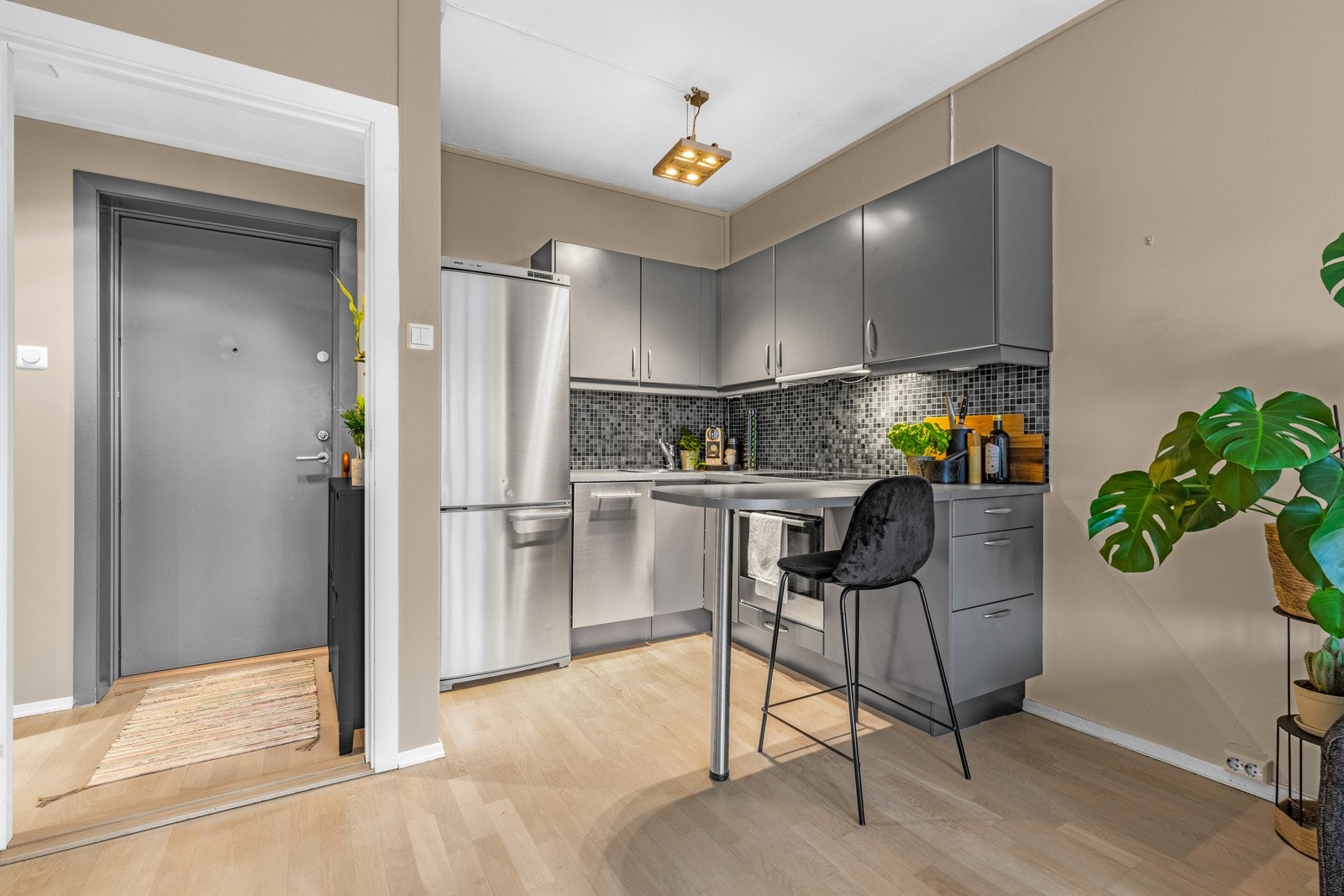 Kjøkken er utstyrt med grå glatt kjøkkeninnredning, laminat benkeplate, fliser over benk, utslagsvask med ett-greps blandebatteri, kjøkkenventilator og oppvaskmaskin. Galleribilde