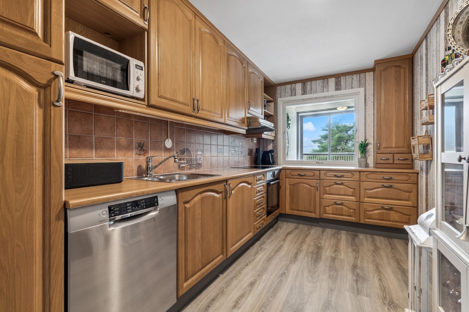 Kjøkkenet er beliggende i eget rom, like ved stuen. Innredningen er trolig fra 90-tallet, og er med heltre fronter og laminert benkeplate. Galleribilde