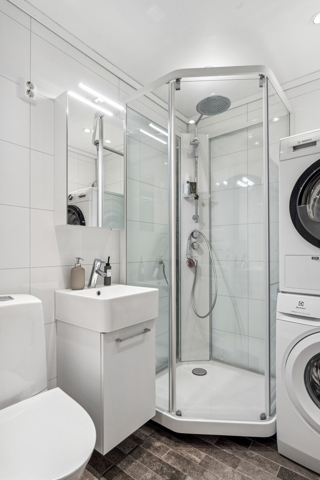 Rommet er utstyrt med servant med underskap, toalett og dusjkabinett. Det er opplegg for vaskemaskin på badet, og det er varmekabler i gulv. Galleribilde