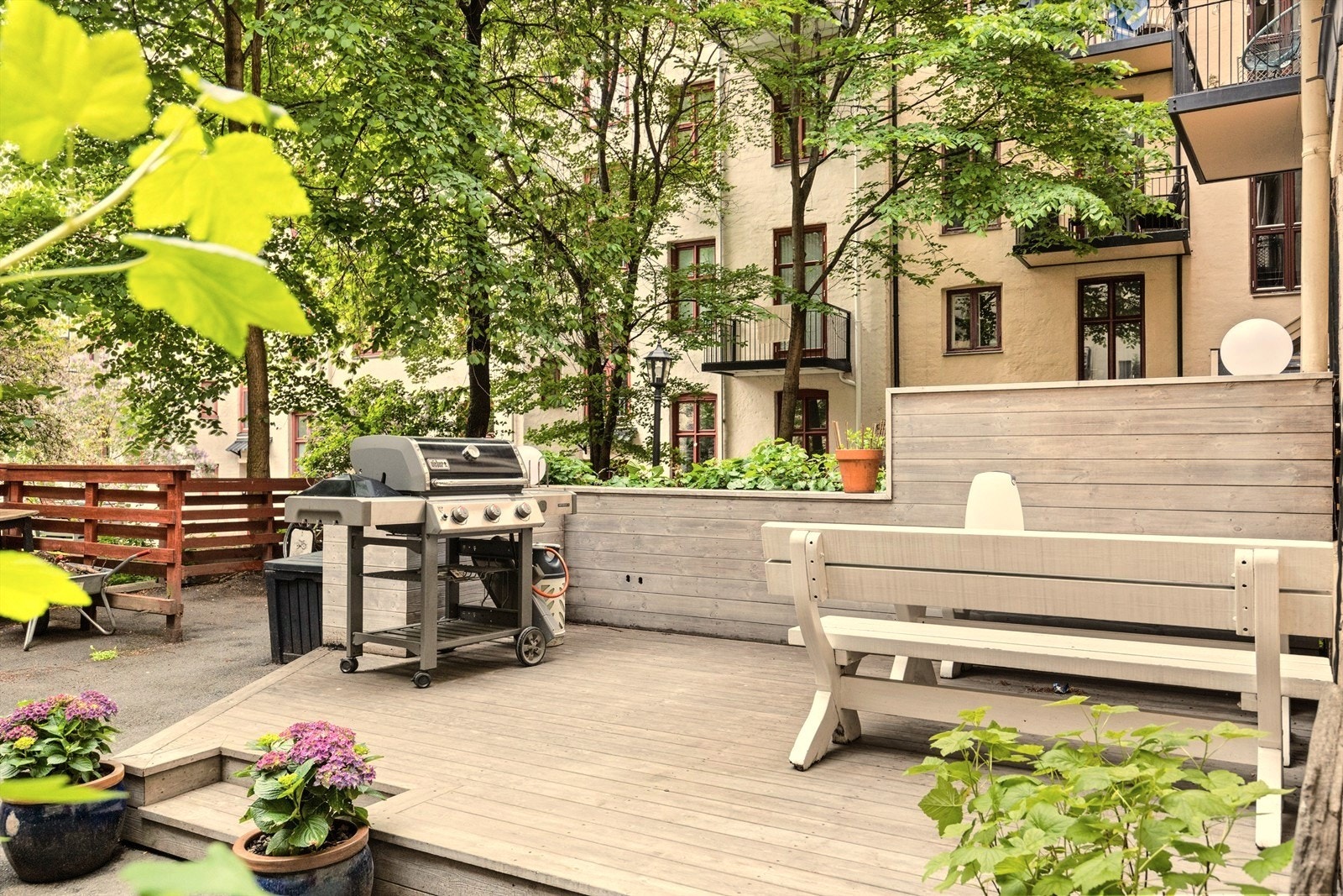 Bakgården er pent opparbeidet med platting, beplantning, plantekasser, sitegrupper og grill. Galleribilde