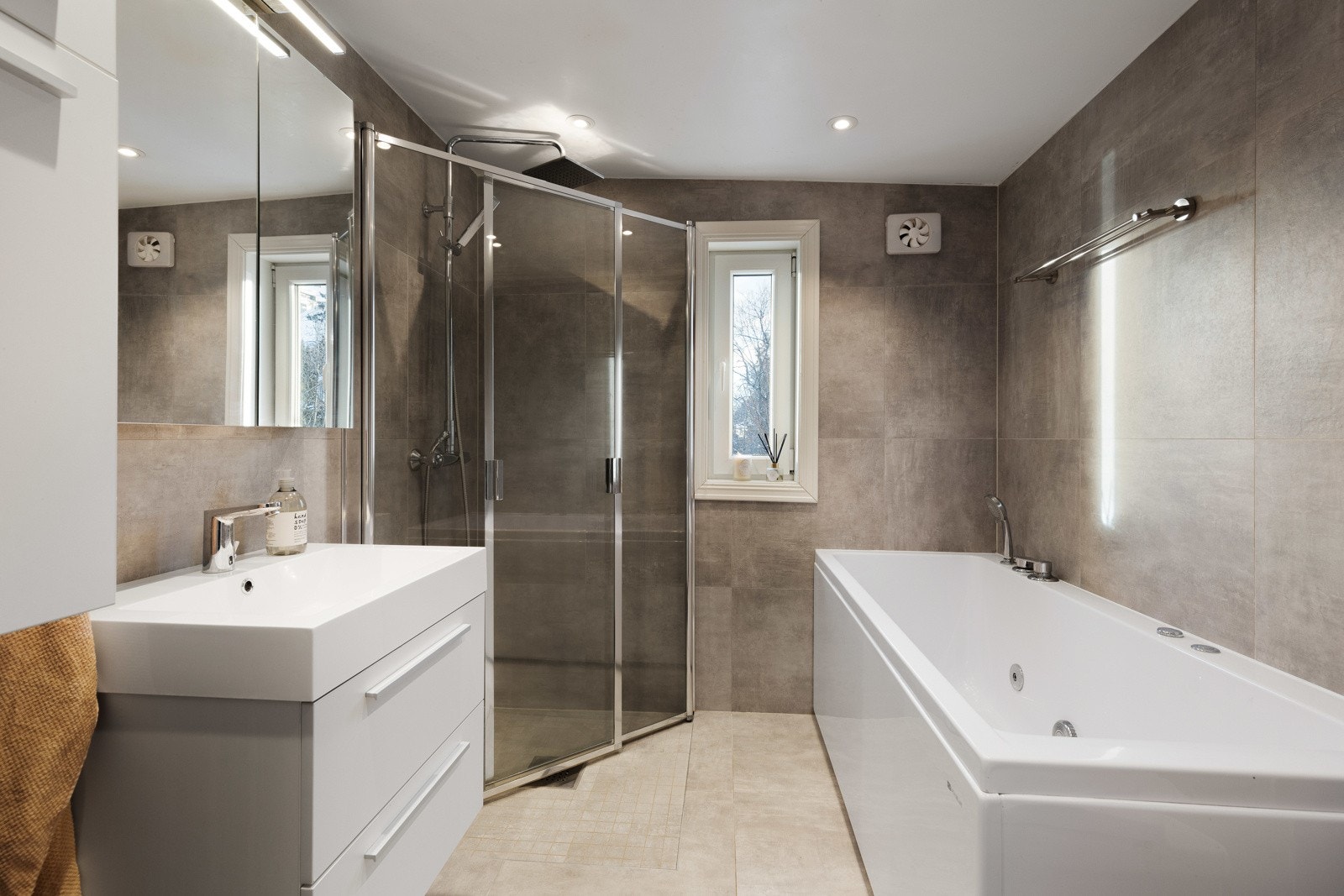 Planløsningen i hoveddelen byr på to bad i hver sin etasje, hvor badet oppe ble lekkert pusset opp i 2016. Her får man et stilrent bad med store vegg- og gulvfliser i ulike gråtoner. Badet har både et dusjhjørne og et badekar med dusjløsning. Galleribilde