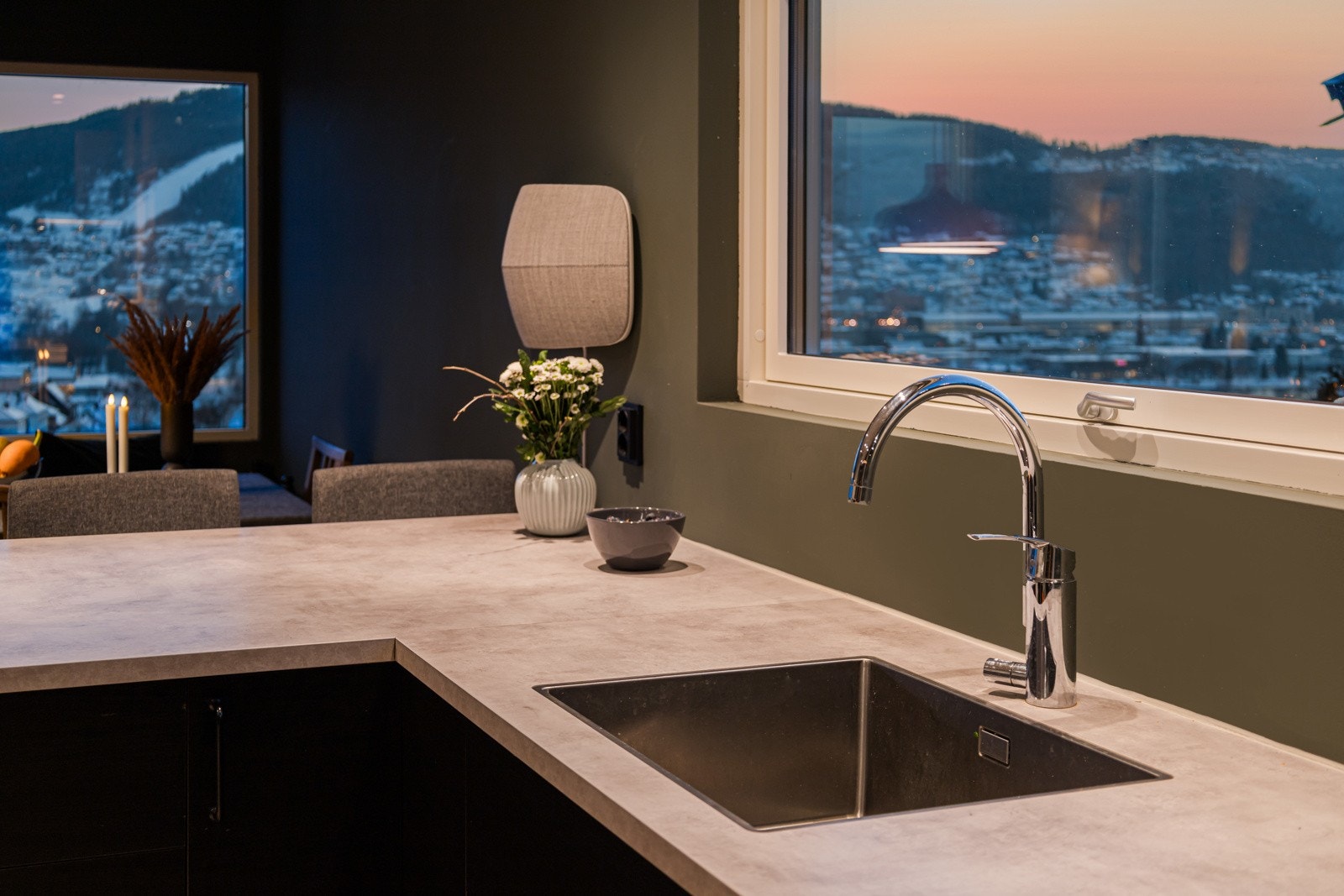 Over benken er det sorte brytere og stikkontakter, og over kokesonen er det installert en stilren ventilator med belysning. Galleribilde