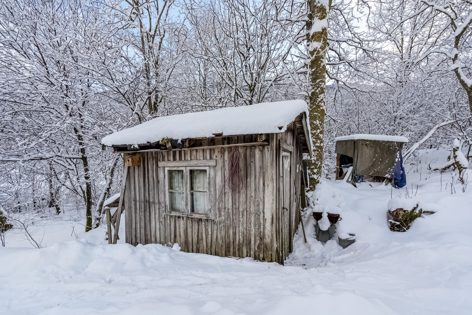 Vedskjulet ved inngangen til hytta Galleribilde