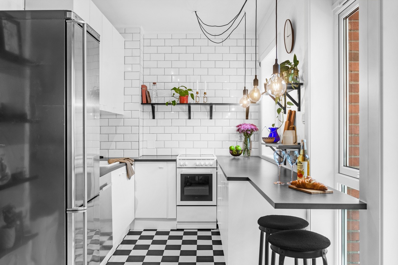 Kjøkkeninnredning med hvite, glatte fronter og laminat benkeplate med utslagsvask. Galleribilde