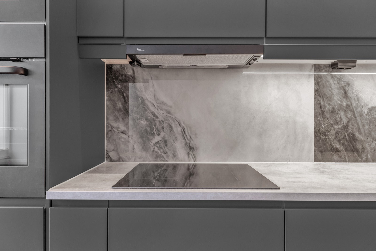 Det er montert nydelige fliser på veggen mellom benkeplaten og overskap Galleribilde