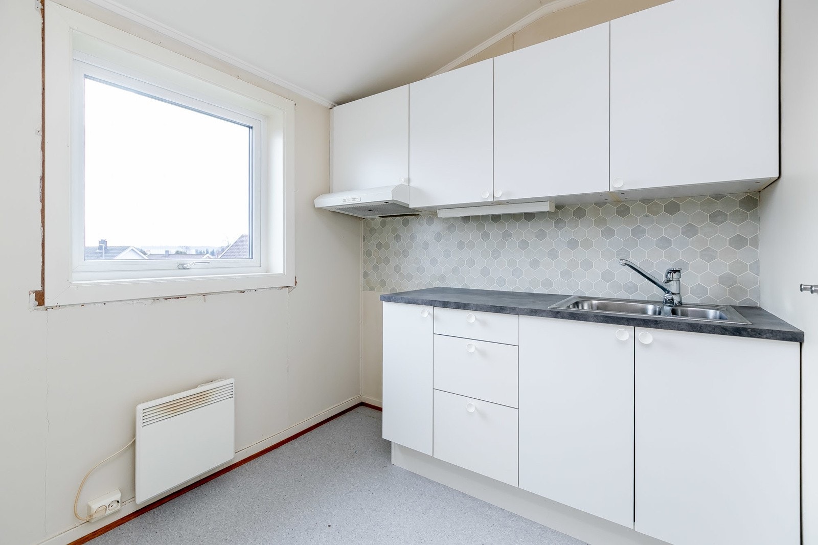 Kjøkken har innredning med slette fronter og laminat benkeplate Galleribilde