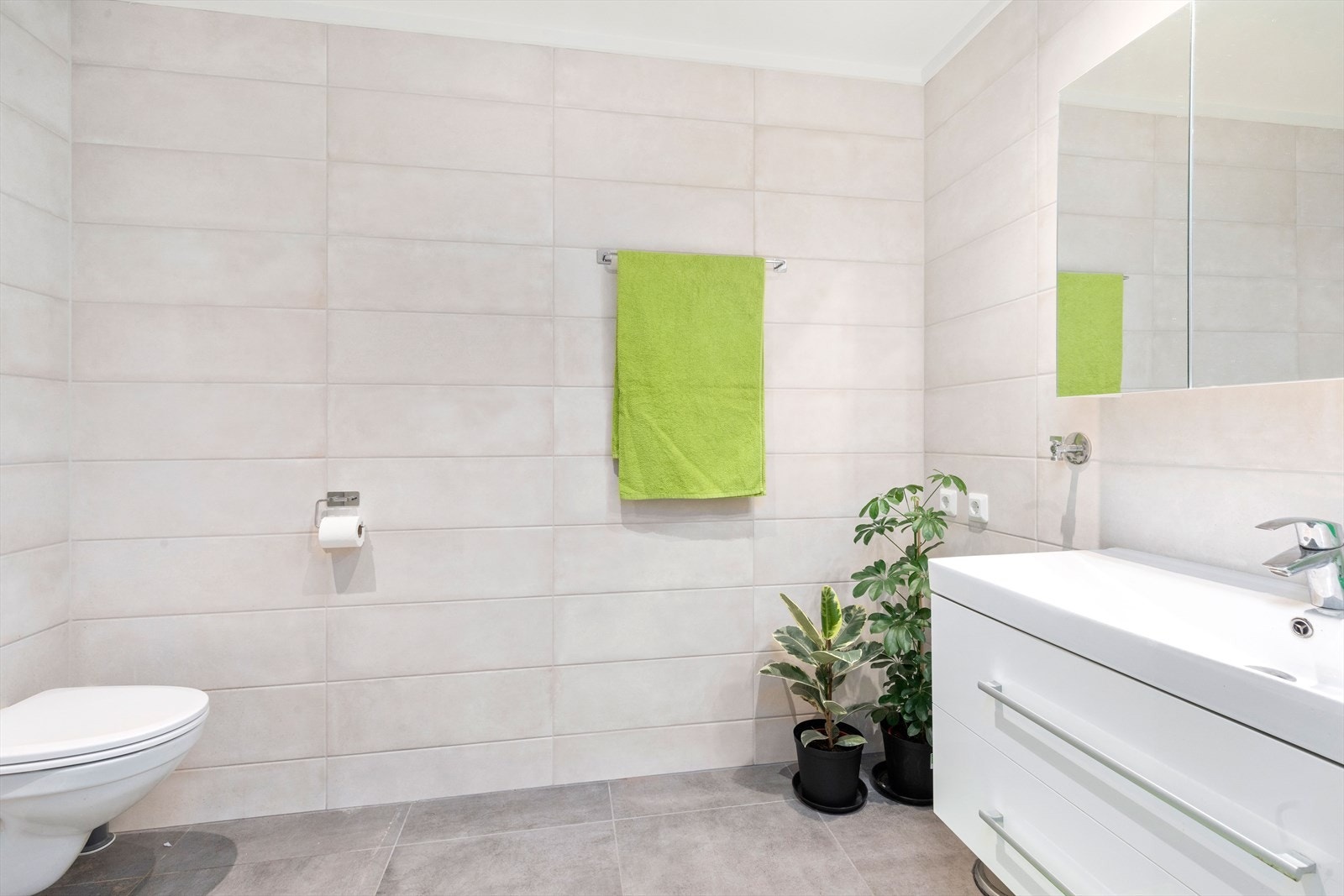 Badet er fliselagt med vegghengt WC og dusjnisje Galleribilde
