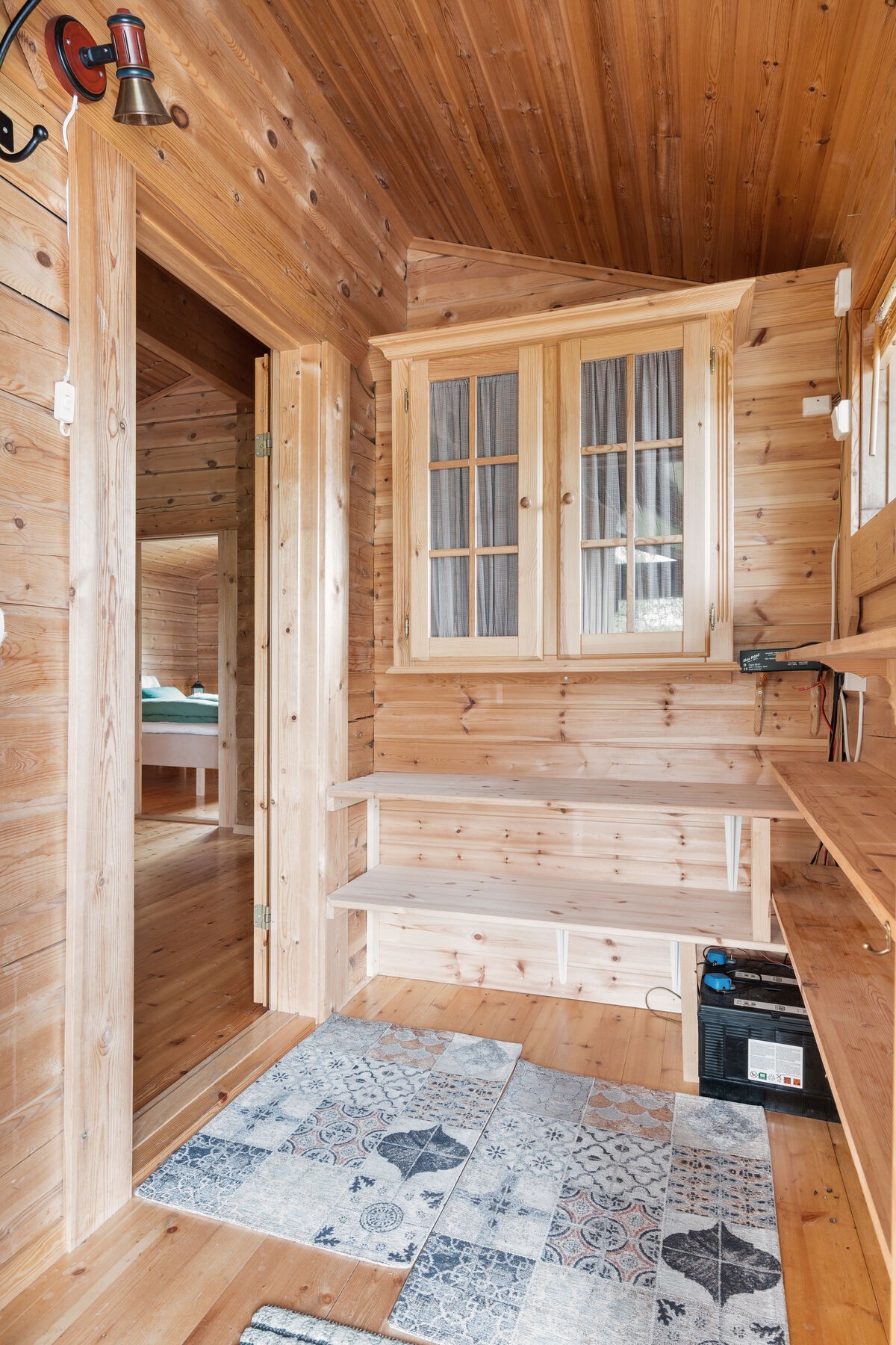 Gang, med plassbygde skohyller og plas sfor bateribanken ti 12 v. anlegget Galleribilde