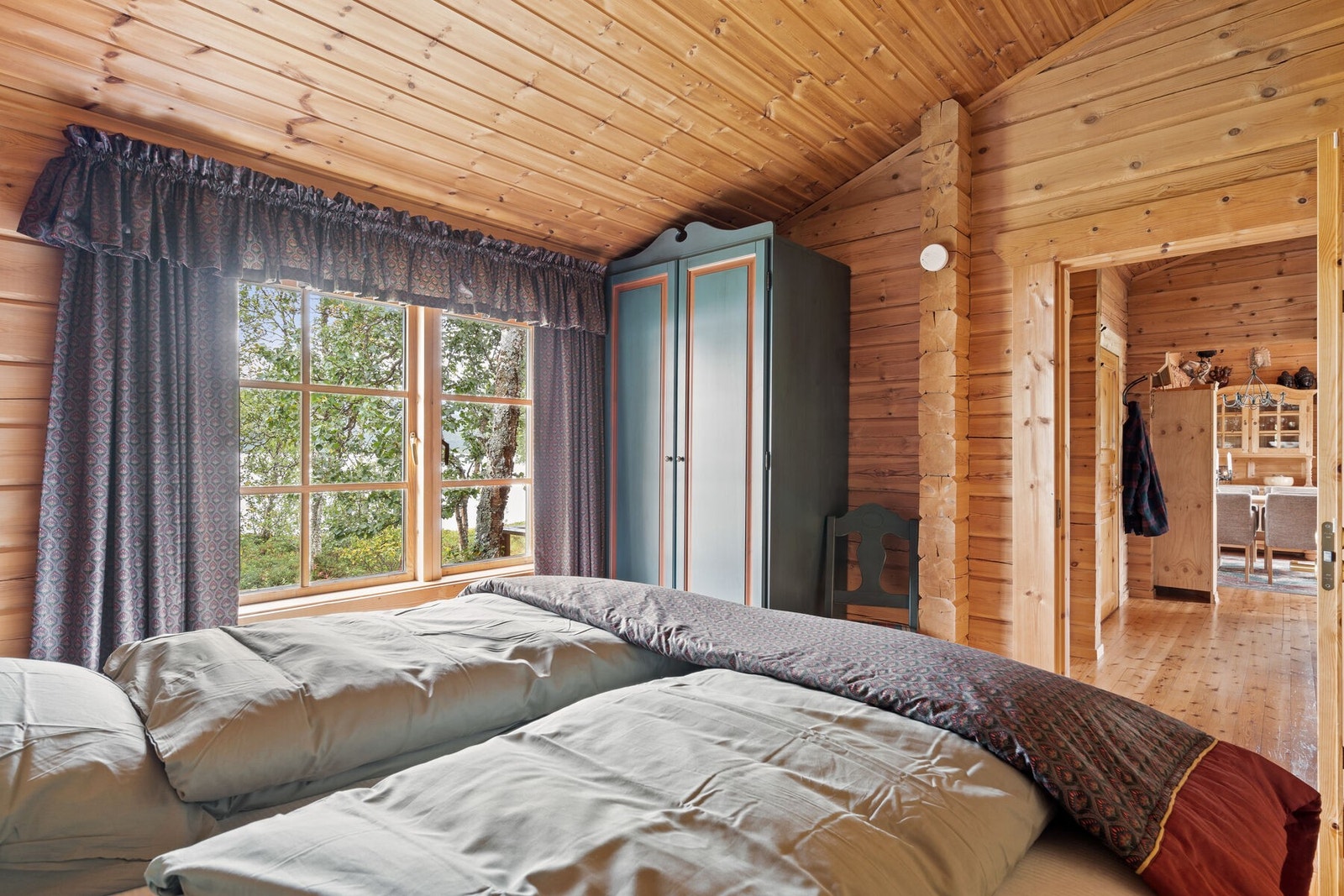 Hytten har to soverom med store vinduer ut mot vannet Galleribilde