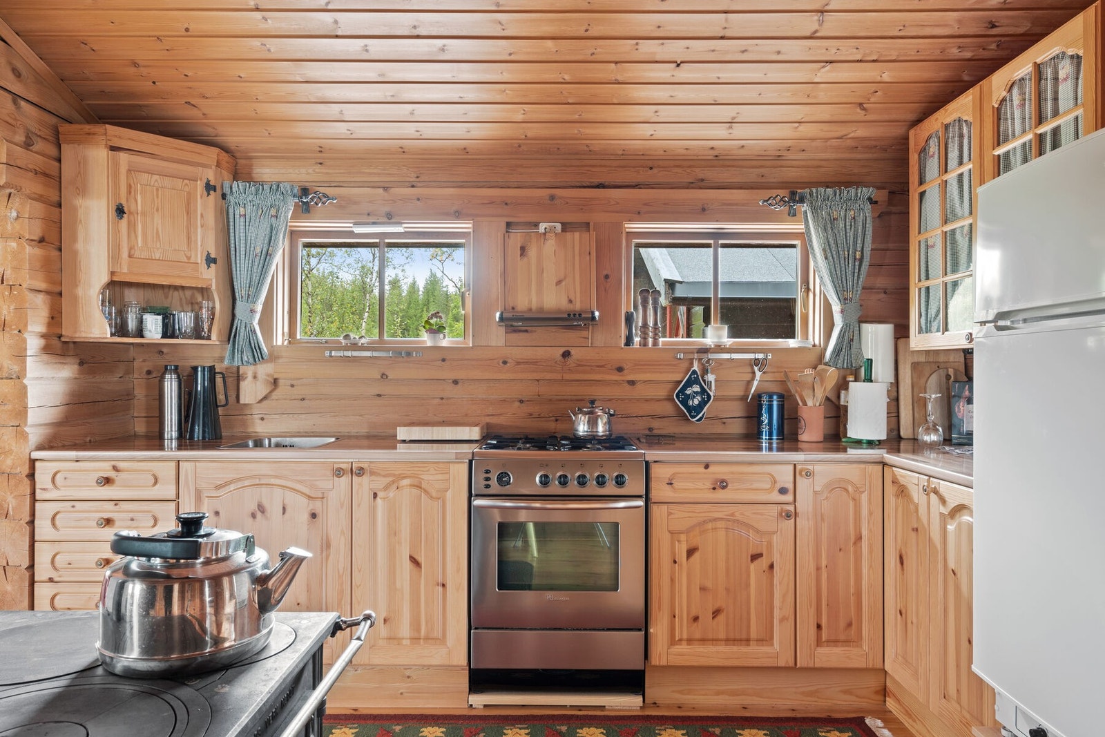 Stort kjøkken med gassdrevet kjøleskap og komfyr, samt vedfyrt kjøkkenovn Galleribilde