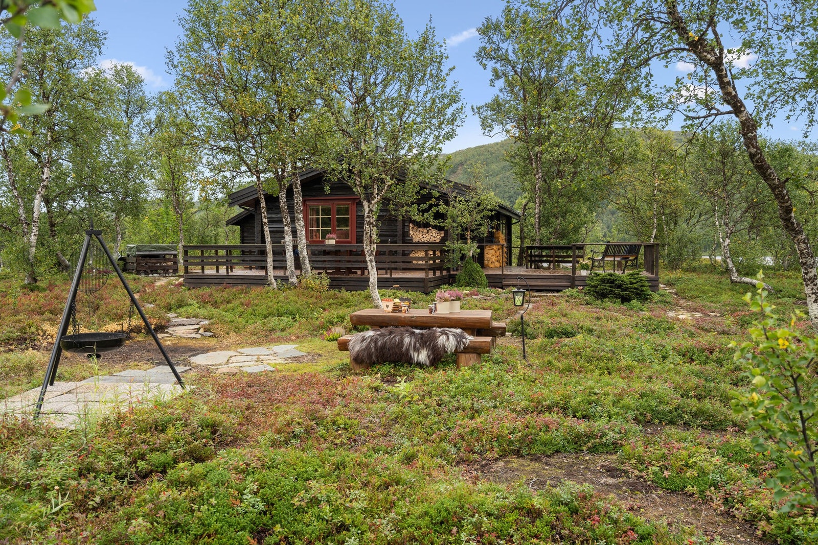 Dagens eier har laget et flott bålsted med sittebenk, i trygg avstand fra hytta Galleribilde