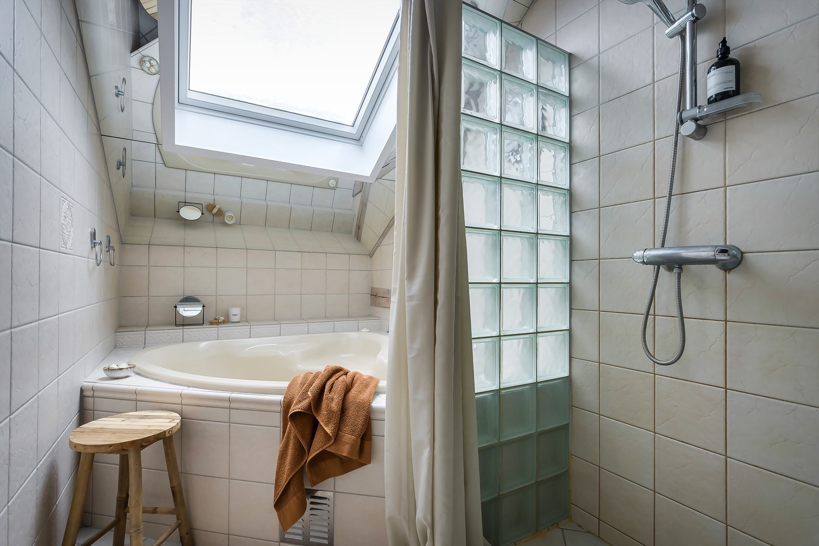 Flislagt bad med varmekabler i gulv. Det store takvinduet gir rikelig med naturlig lys. Galleribilde