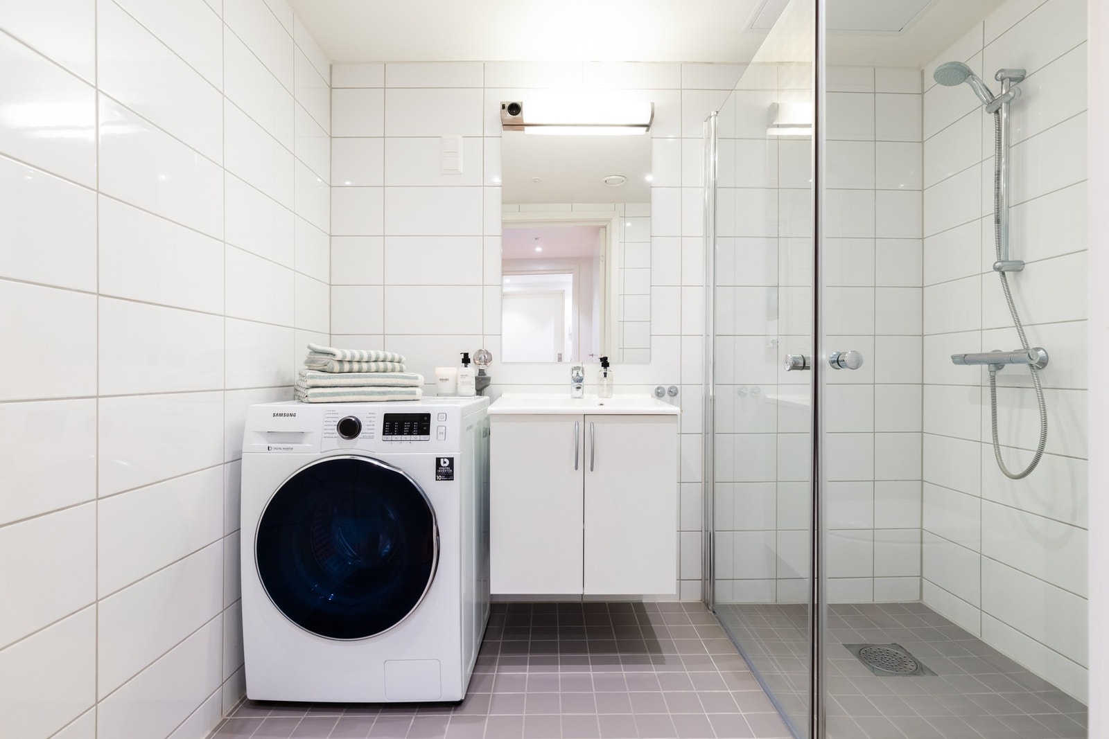 Videre er det dusjhjørne med innfellbare glassdører som frigjør plass på gulvet. Badet har opplegg for vaskemaskin og plass til tørketrommel. Mekanisk avtrekksventil i himling. Galleribilde