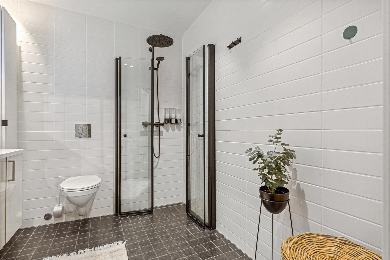 Badet har dusjhjørne med sort regnfallsdusj og innfellbare glassdører med sorte rammer. Galleribilde