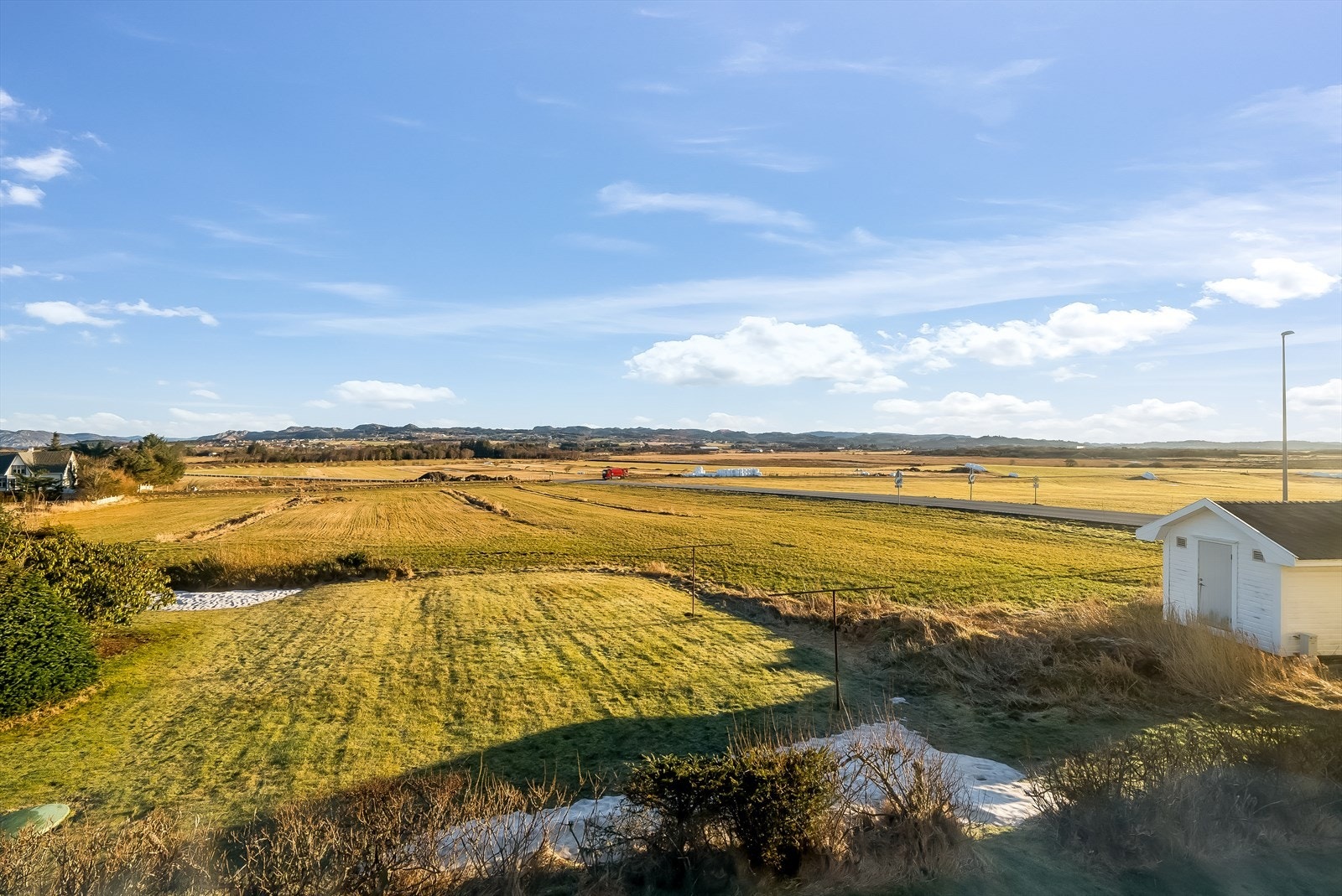Fin utsikt over jordet og mot fjellene. Galleribilde