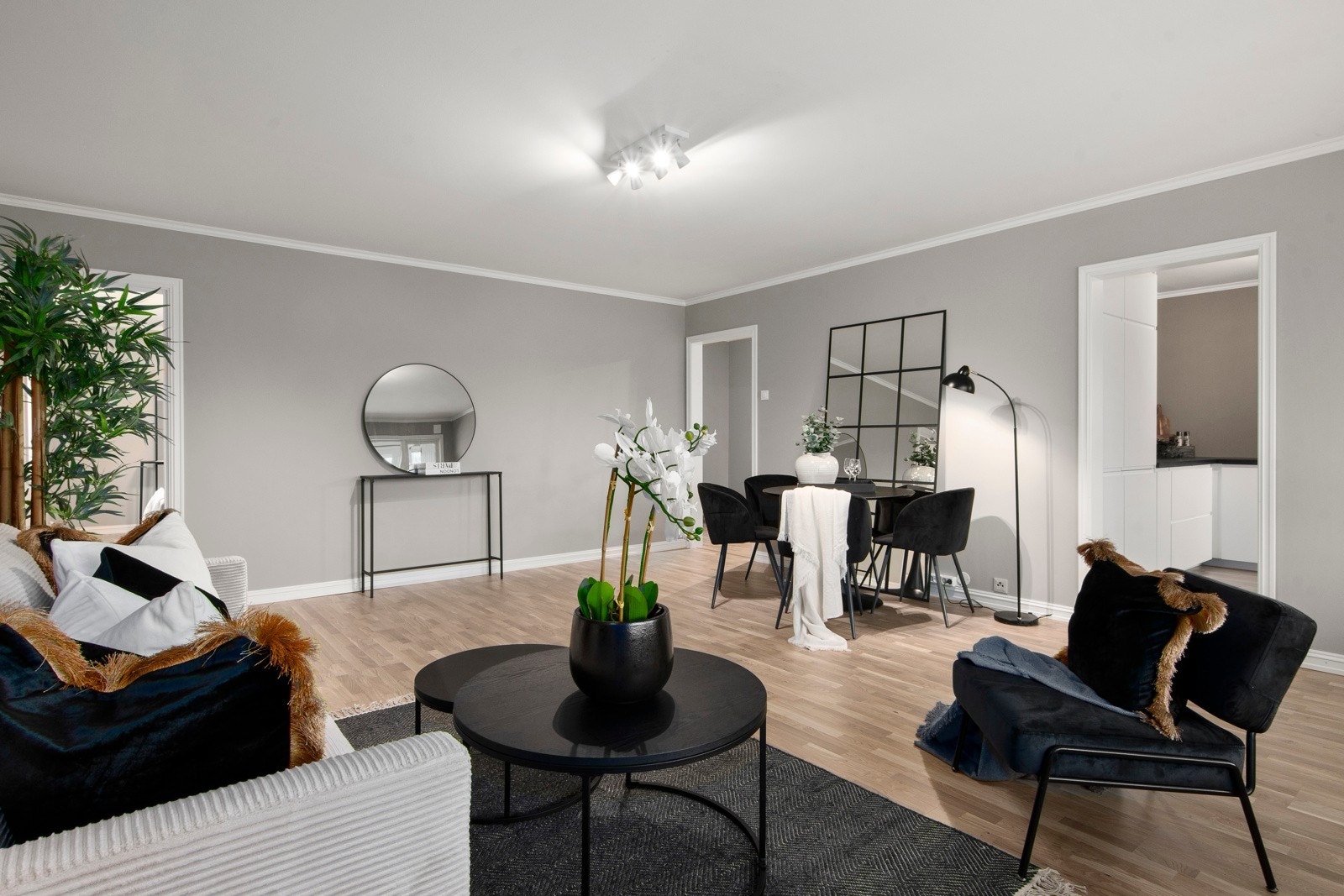 Leiligheten har en stor stue med plass til både stor sofa, mediemøblement og spisestue Galleribilde