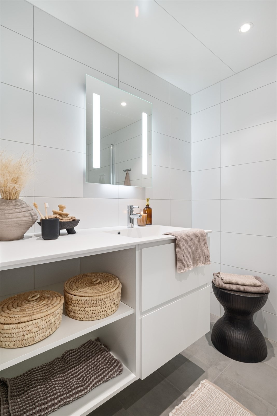 Badet et utstyrt med servantskap, vegghengt toalett og innfellbare dusjdører Galleribilde