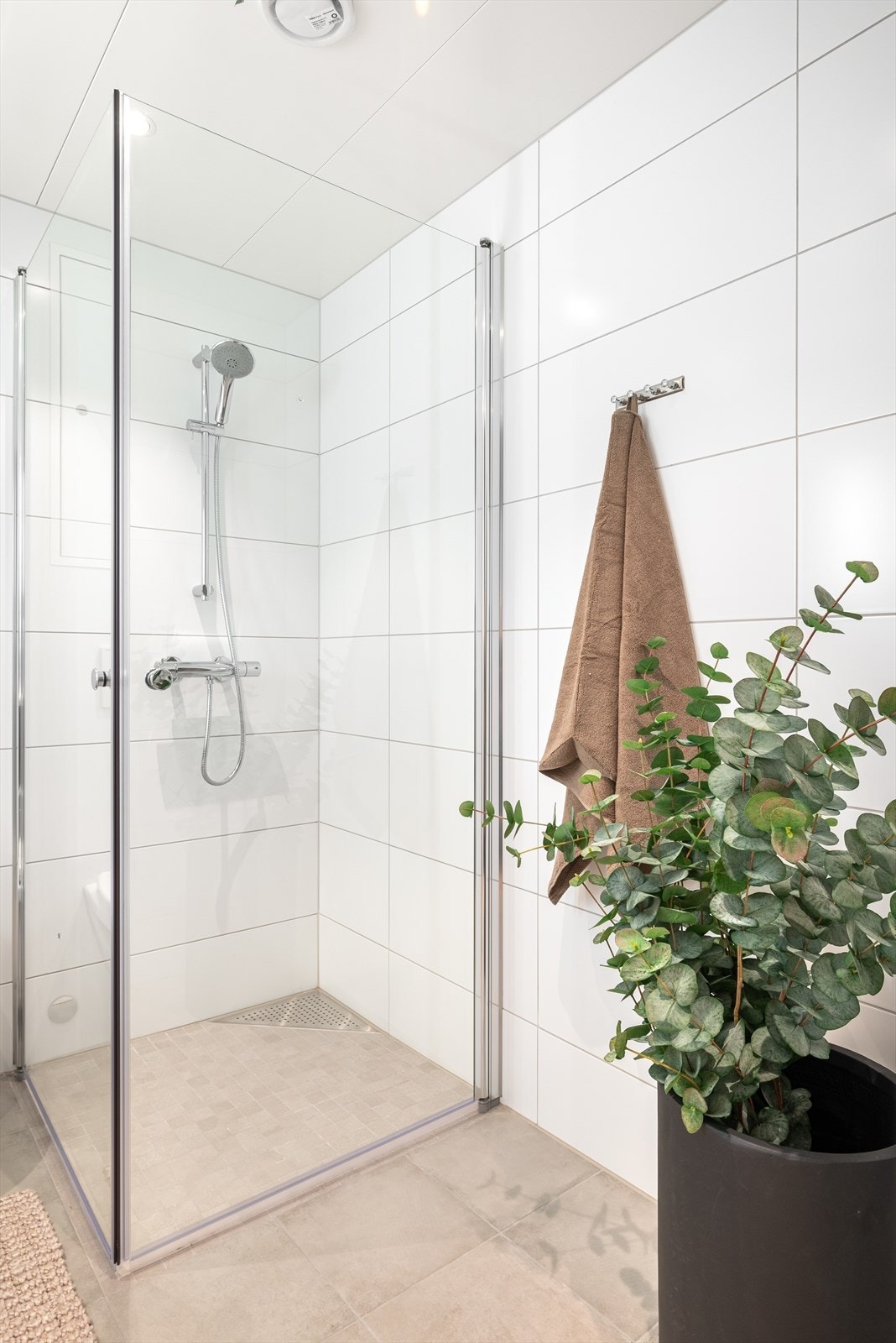 Badet er utstyrt med vegghengt toalett, innfellbare dusjvegger og servantskap Galleribilde