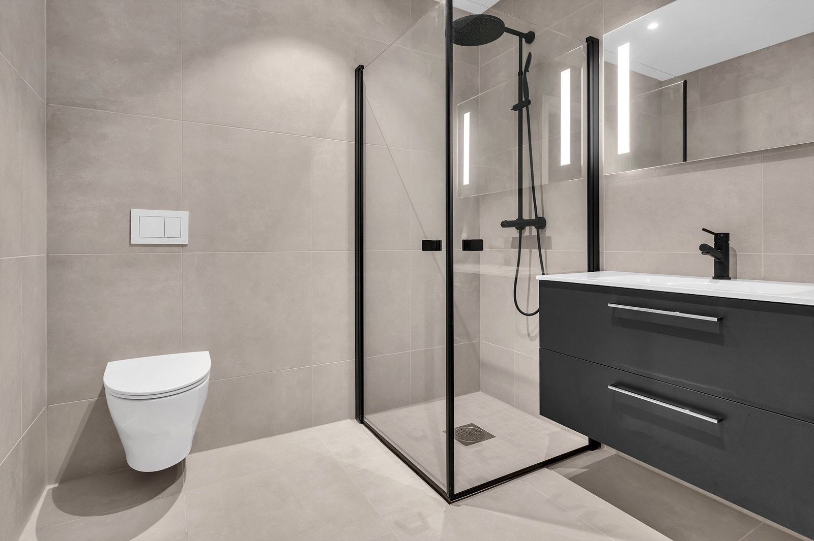 Foto fra Kongsgård Hageby 5 - Lekkert baderom fliselagt med 60X60 fliser i gråtone. Innredning fra Viking Bad. Speil med belysning. Galleribilde