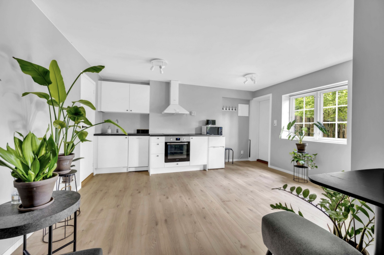 The kitchen in the apartment is kept in white design with plain fronts and laminate worktop. Integrated appliances include a dishwasher, microwave, oven and stove. Galleribilde