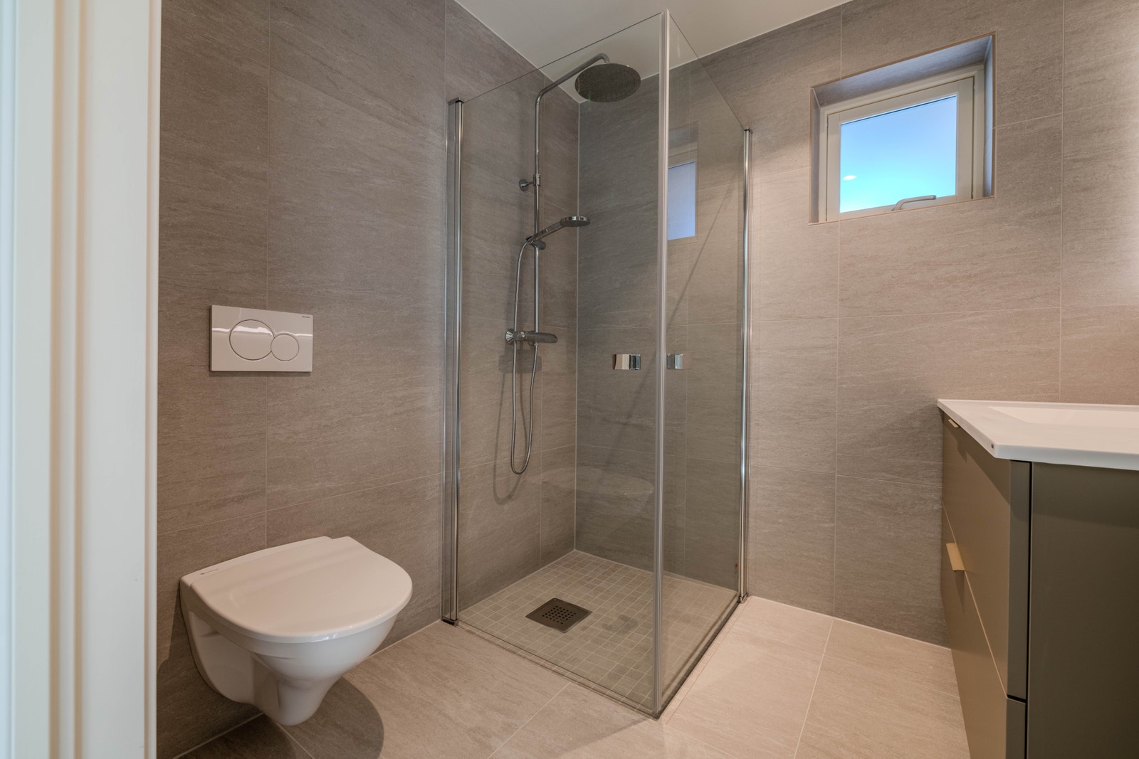 Takdusj, dusjveggar og veggmontert toalett Galleribilde