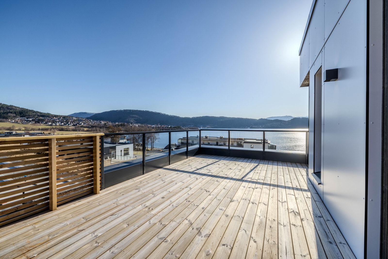 Takterrasse over carport med god plass til uteliv og ønska møblering. Glassfelt i deler av rekkverk sikrar utsikta. Galleribilde