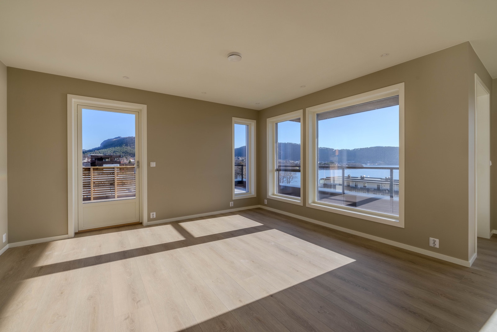 Nyt utsikta! Hyggeleg stuedel med slette overflater i ein behageleg farge og laminatgolv av god kvalitet Galleribilde