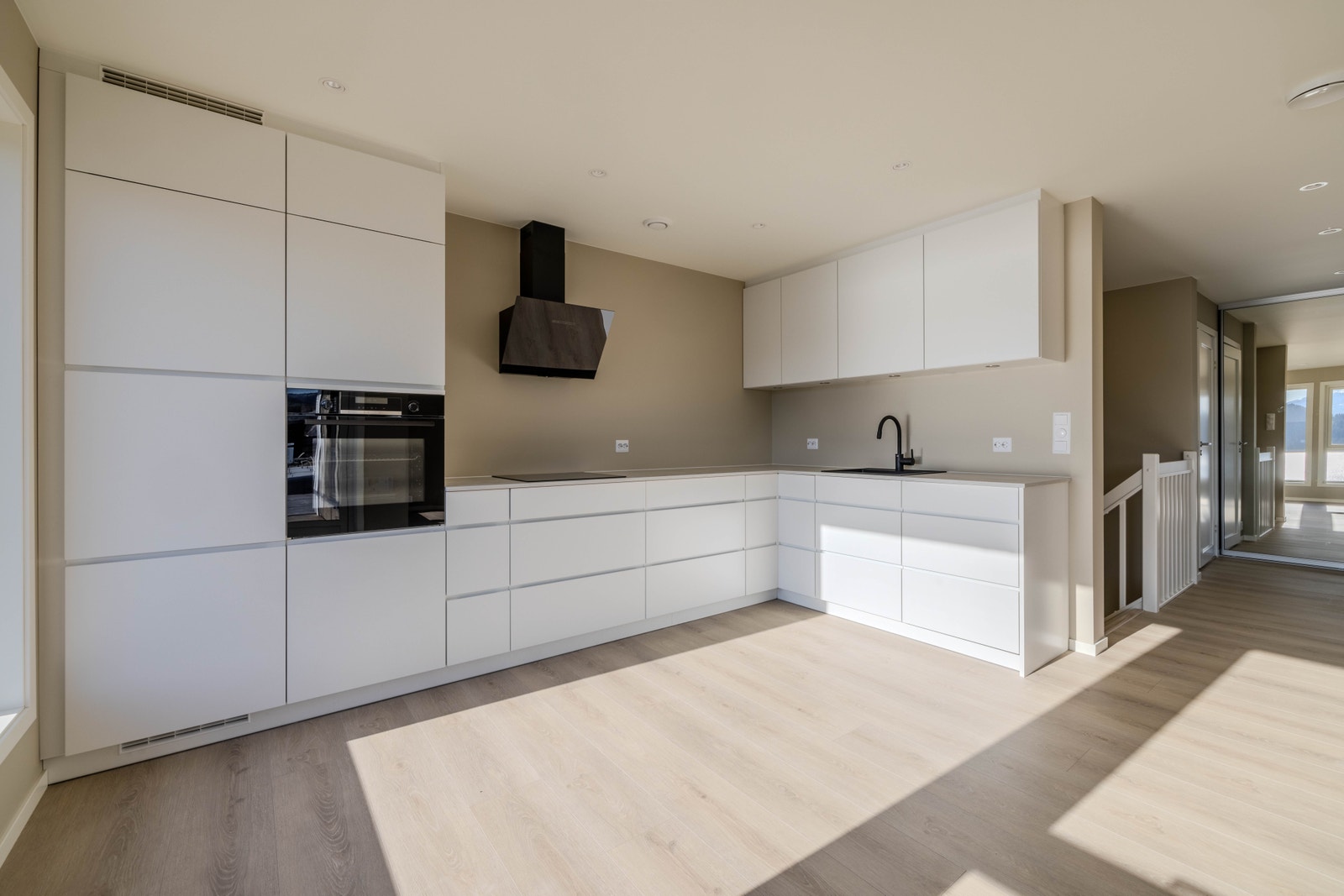 Moderne, men tidlaust kjøkken med god benkeplass og integrerte kvitevarer Galleribilde