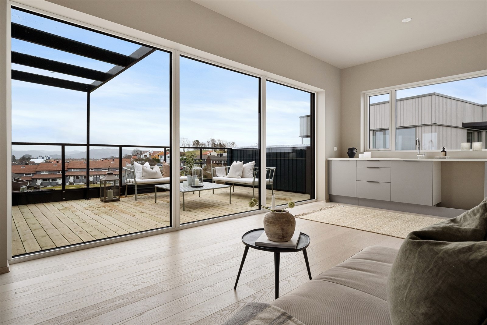 Store vindusflater mot takterrassen slipper inn rikelig naturlig sollys. Galleribilde