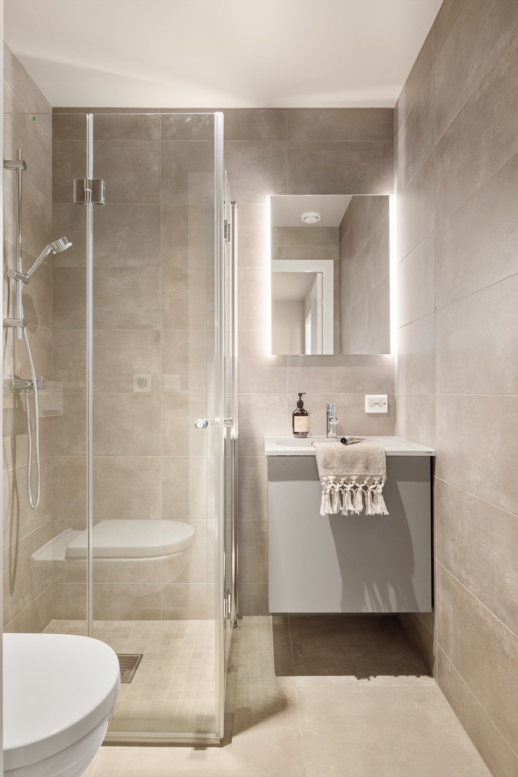 Helfliset gjestebad med dusj, toalett og servant. Galleribilde