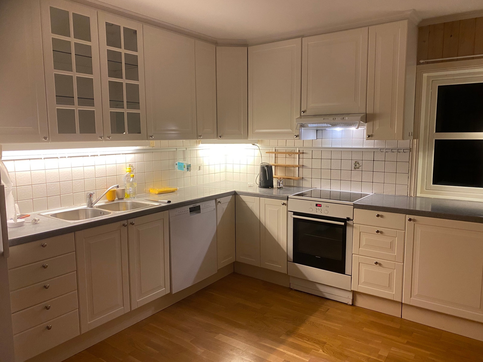 Kjøkken med nye skapdører fra 2022. Induksjonskomfyr, oppvaskmaskin, ventilator. Galleribilde