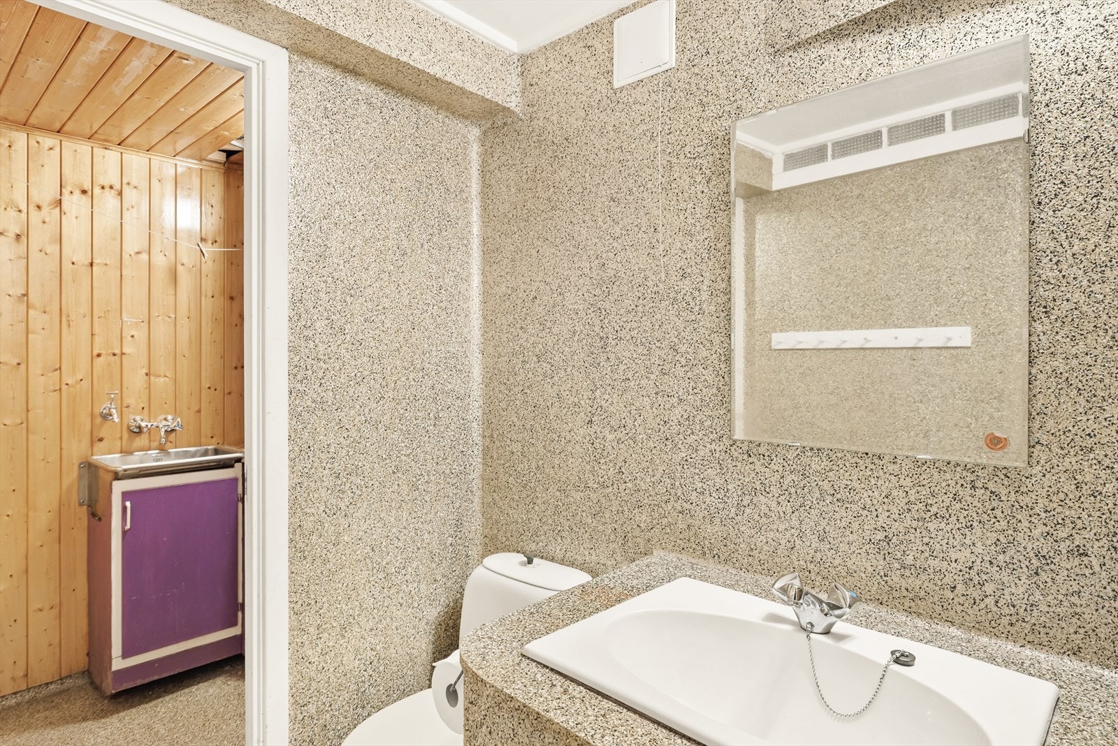 Wc med epoxybelegg på gulv og vegger, malte overflater i himling. Innredningen består av wc og servant med underskap. Galleribilde