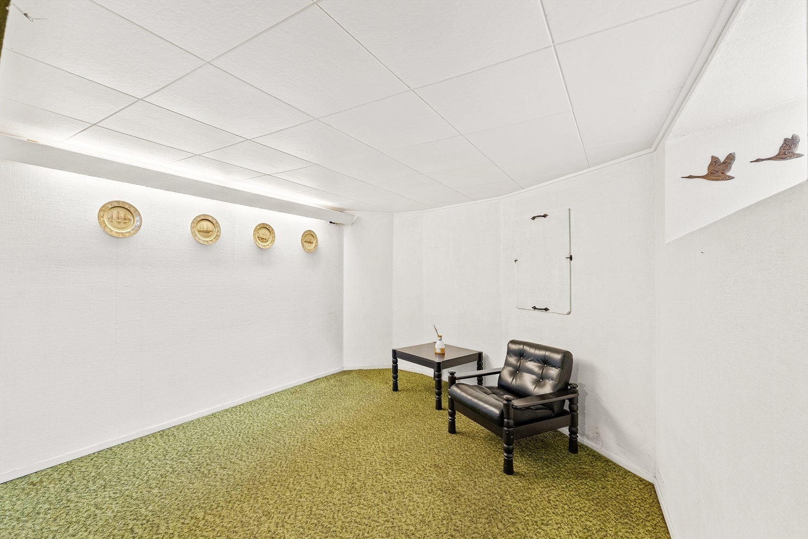 Kjellerstue med t
eppe på gulv, malte tekstilstrier på vegger og malte takplater i tak. Galleribilde