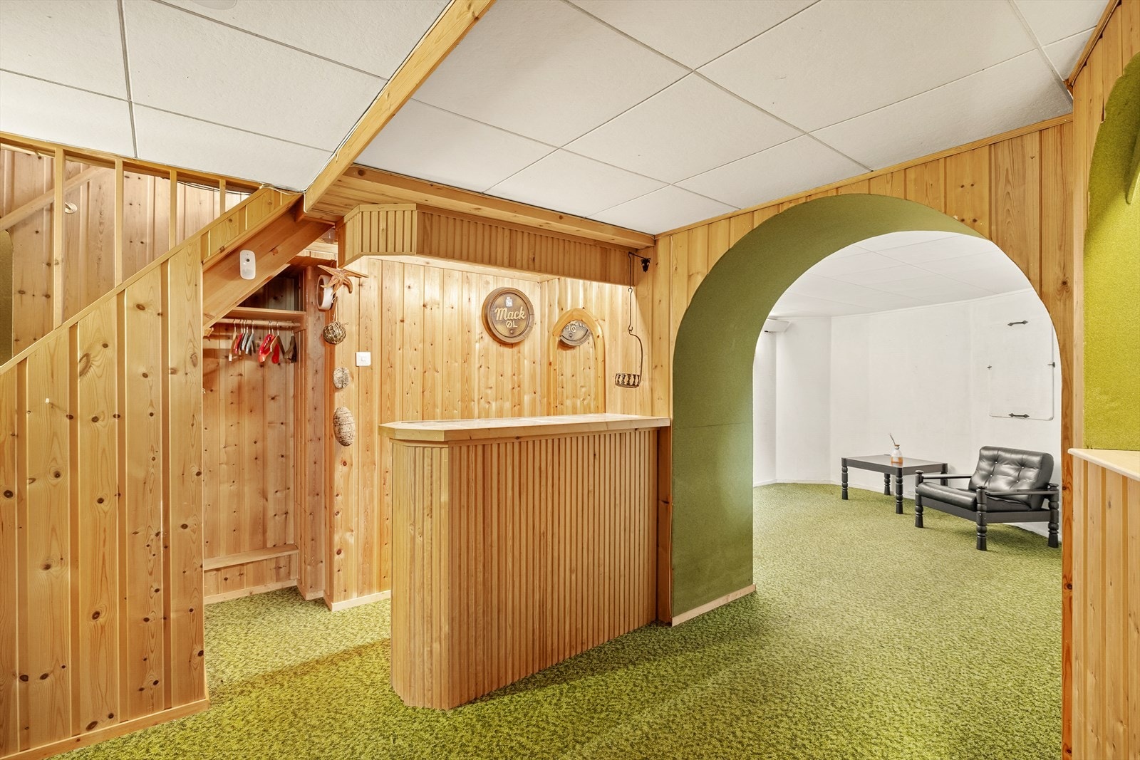 Gang/trapperom med teppe på gulv, panel på vegger og takplater i tak. Galleribilde