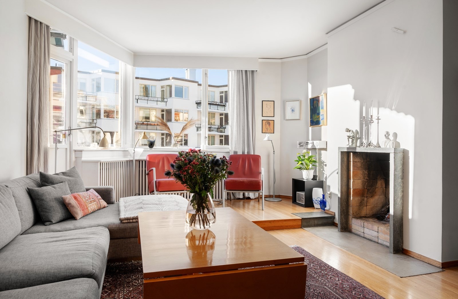 Romslig stue med med åpen peis og plass til sofagruppe, bord og tilhørende møblement. Galleribilde