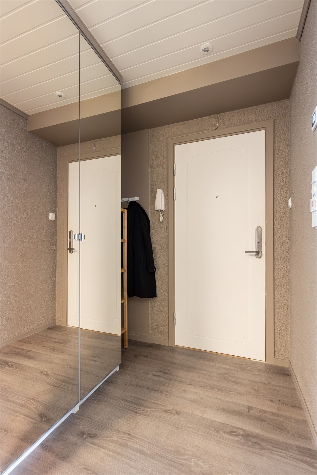 Med enkel adkomst fra felles trappegang kommer man inn i den lyse entréen som er på 3 m2. Her er det en pen, moderne laminat fra 2020 på gulvet som går videre inn i leiligheten og gir en fin helhet. Det er oppbevaringsplass i garderobeskap med speildører. Galleribilde