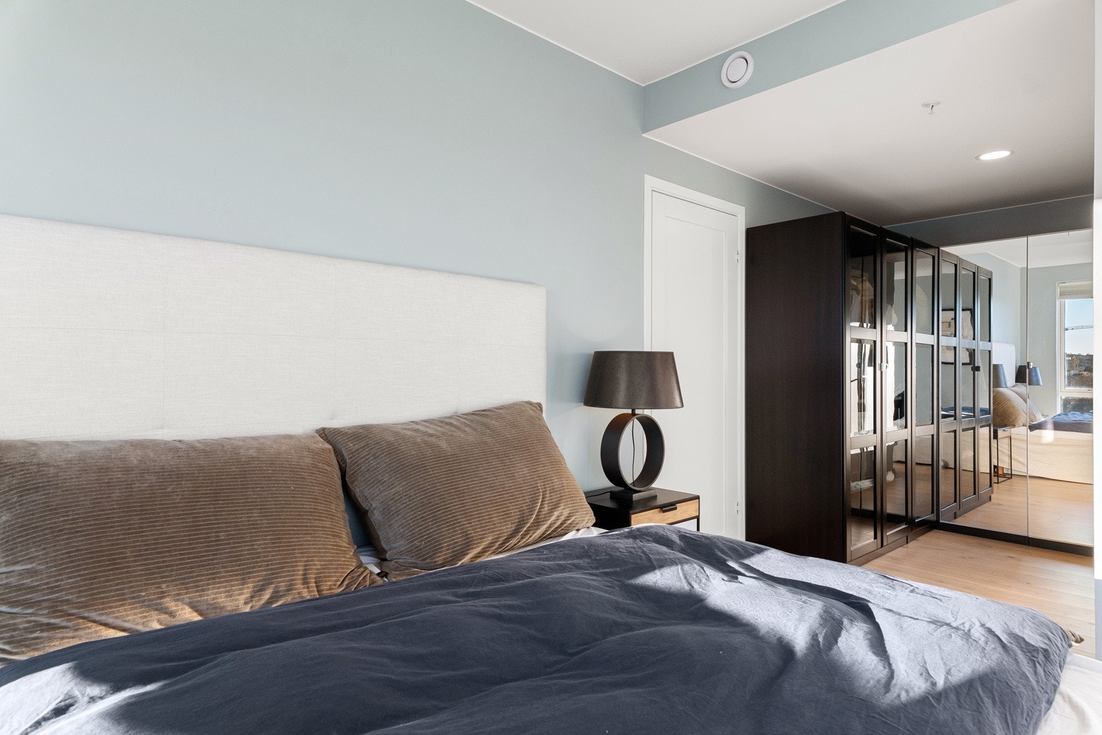 Garderoben består av garderobeskap i en elegant kombinasjon av speilfronter og mørke fronter med glass. Galleribilde