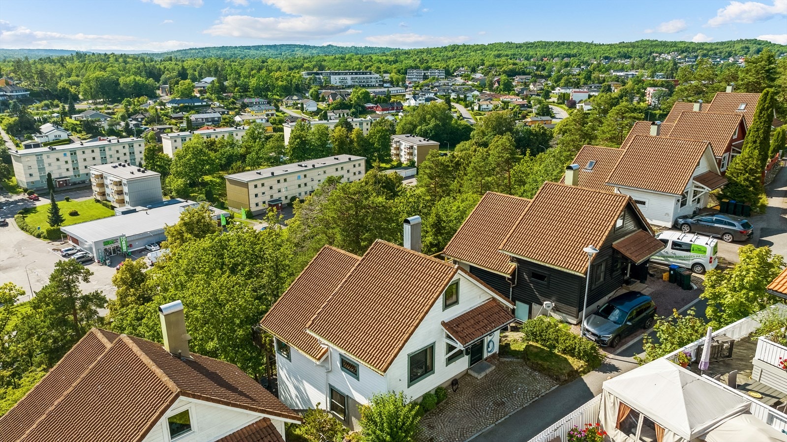 Inngangssiden med steinlagt inngangsparti og p-plass med elbillader. Galleribilde