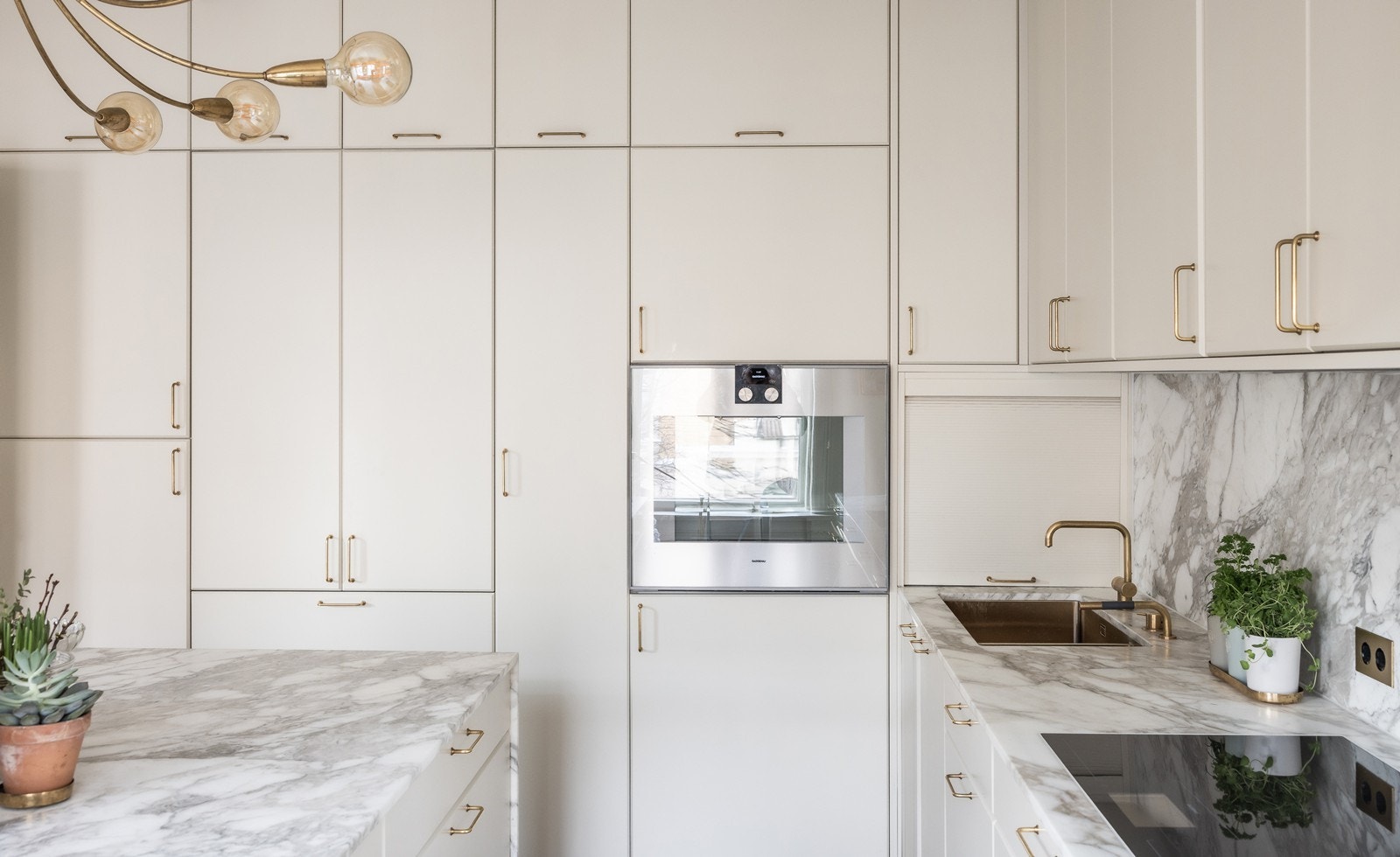 Diverse integrerte hvitevarer fra Gaggenau (kjøl/frys, vinkjøler, platetopp og stekeovn) og MIELE (oppvaskmaskin), samt praktisk sjalusiskap med stikkontakter til kjøkkenmaskiner i hjørnet Galleribilde