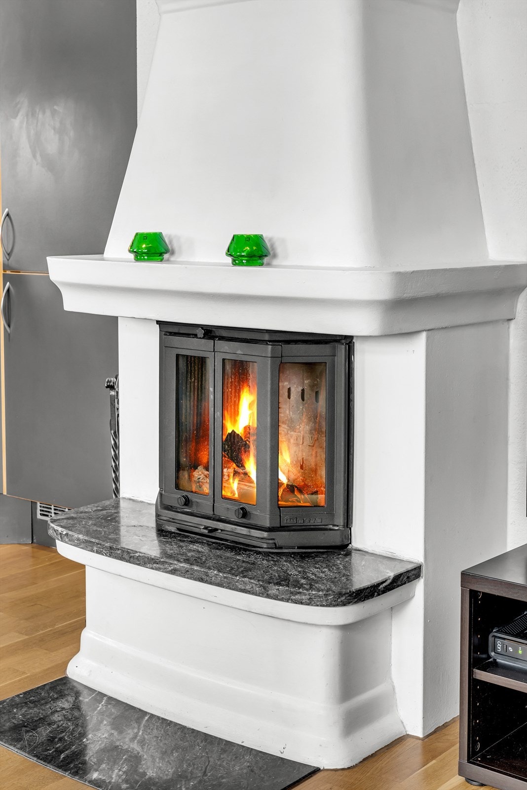 Stemningsfull elementpeis med glassdør på innsats og flis montert foran peis Galleribilde