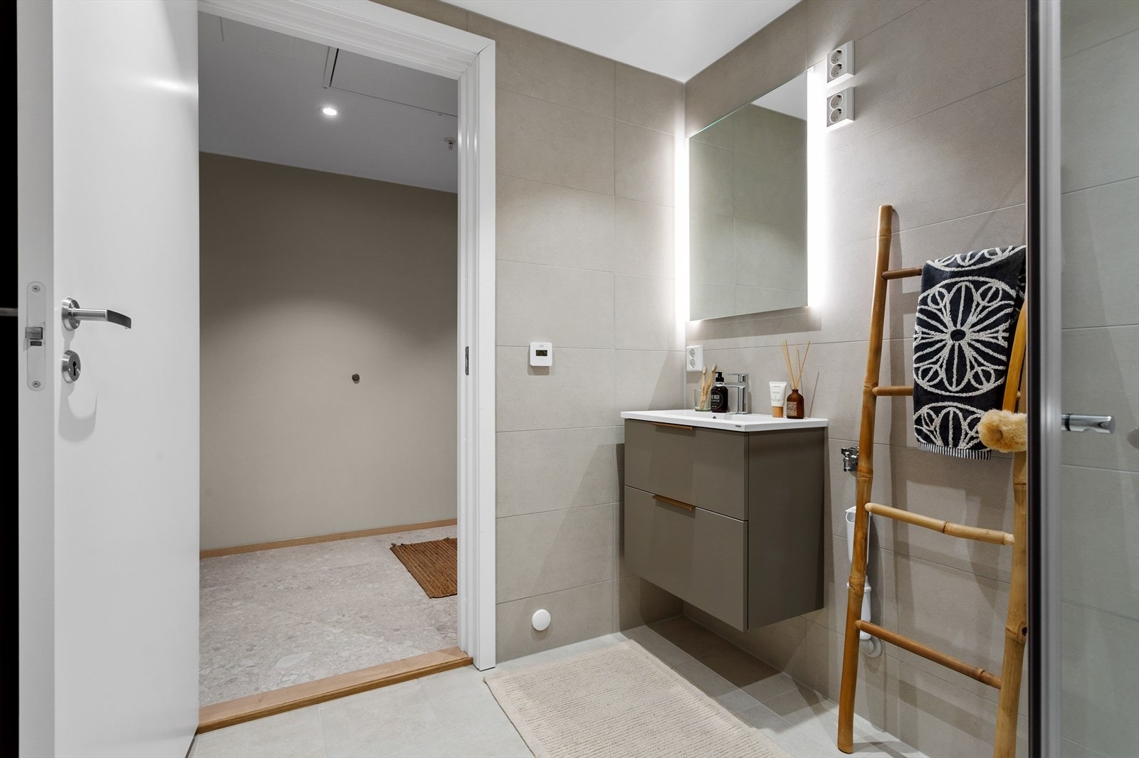 Baderomsinnredning i delikate materialer, her får du servantinnredning med skuffeseksjon, dusjsone og vegghengt toalett. Galleribilde