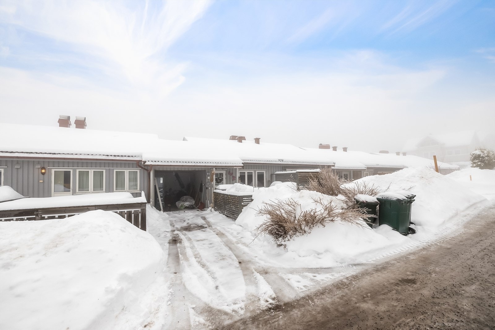 Tomannsboligen har egen carport og sportsbod med parkering foran carporten. Galleribilde