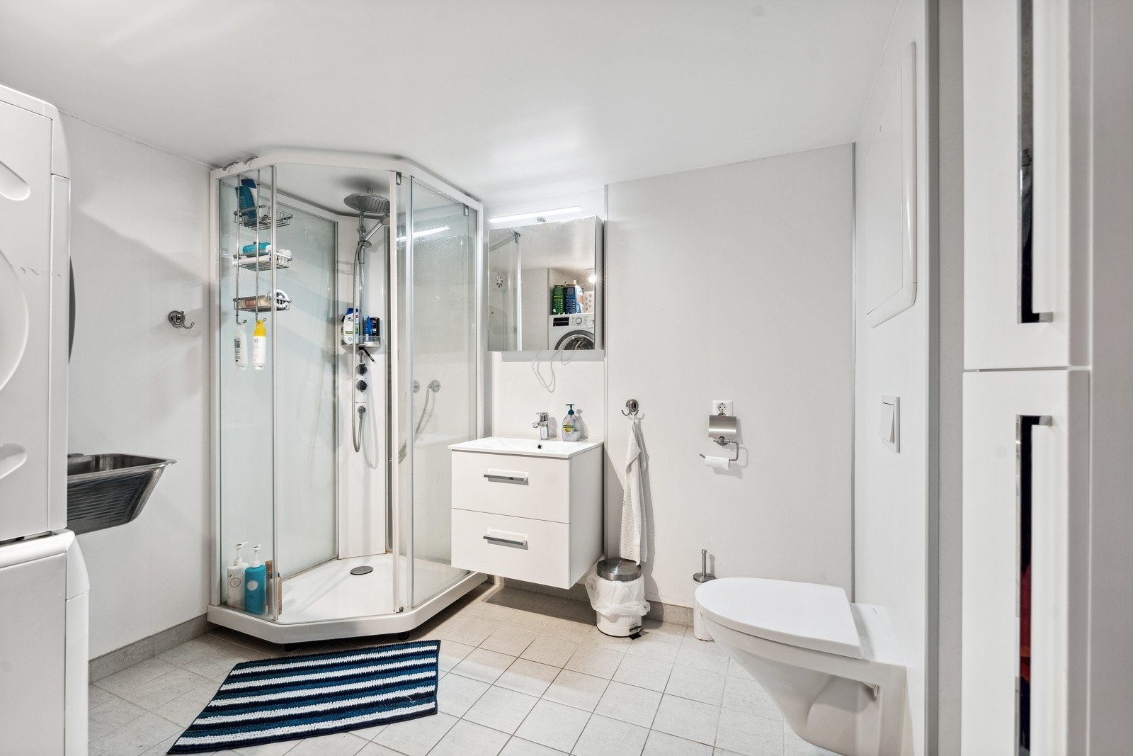 Utleiedelen har et eget baderom og et separat toalettrom. Baderommet på hele 8 kvm har flislagt gulv med herlig varme i, dusjkabinett, en moderne innredning med speilskap og belysning, samt opplegg for vaskemaskin. Galleribilde