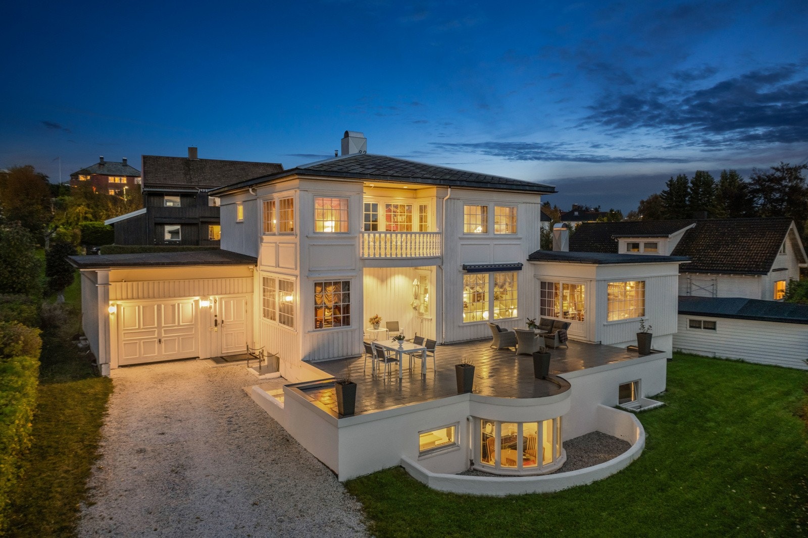 Eiendommen er omkranset av høye hekker som skjermer for innsyn og uteområdet består av en stor opparbeidet gårdsplass, med biloppstillingsplass og to store garasjer. Galleribilde